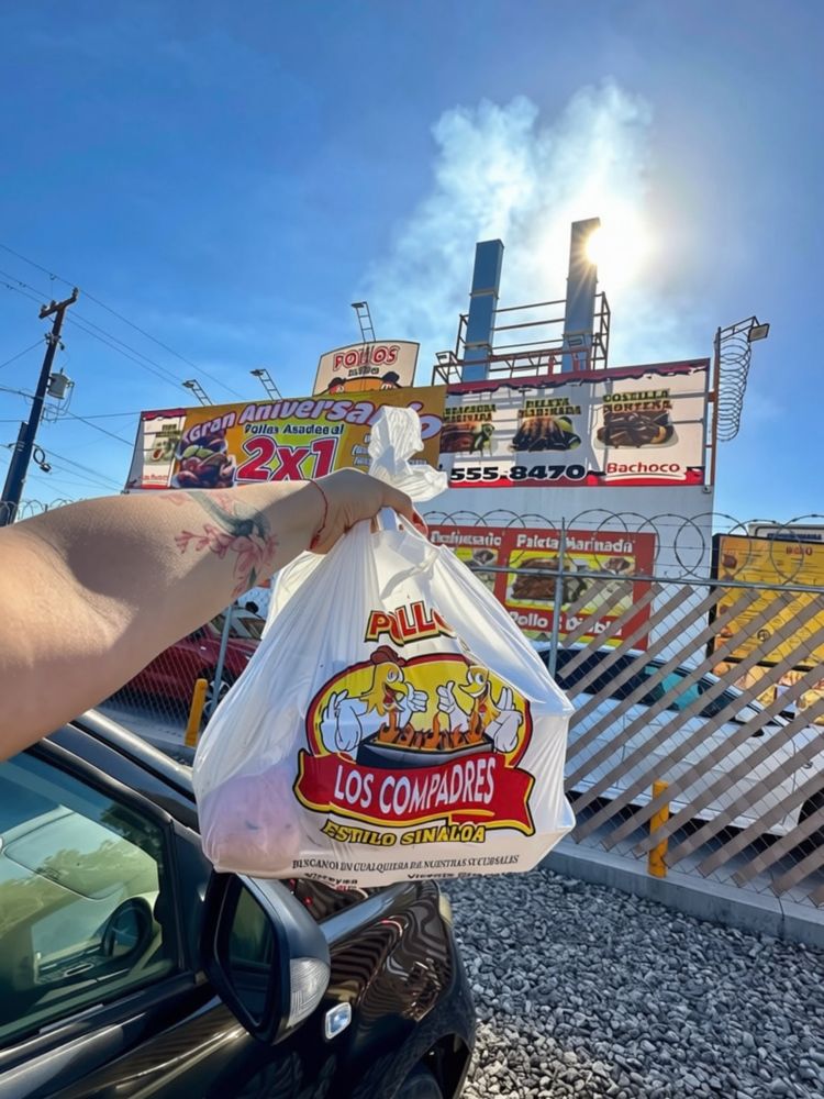 Mano con la bolsa de Los Compadres frente a la sucursal Virreyes, con el humo de las chimeneas